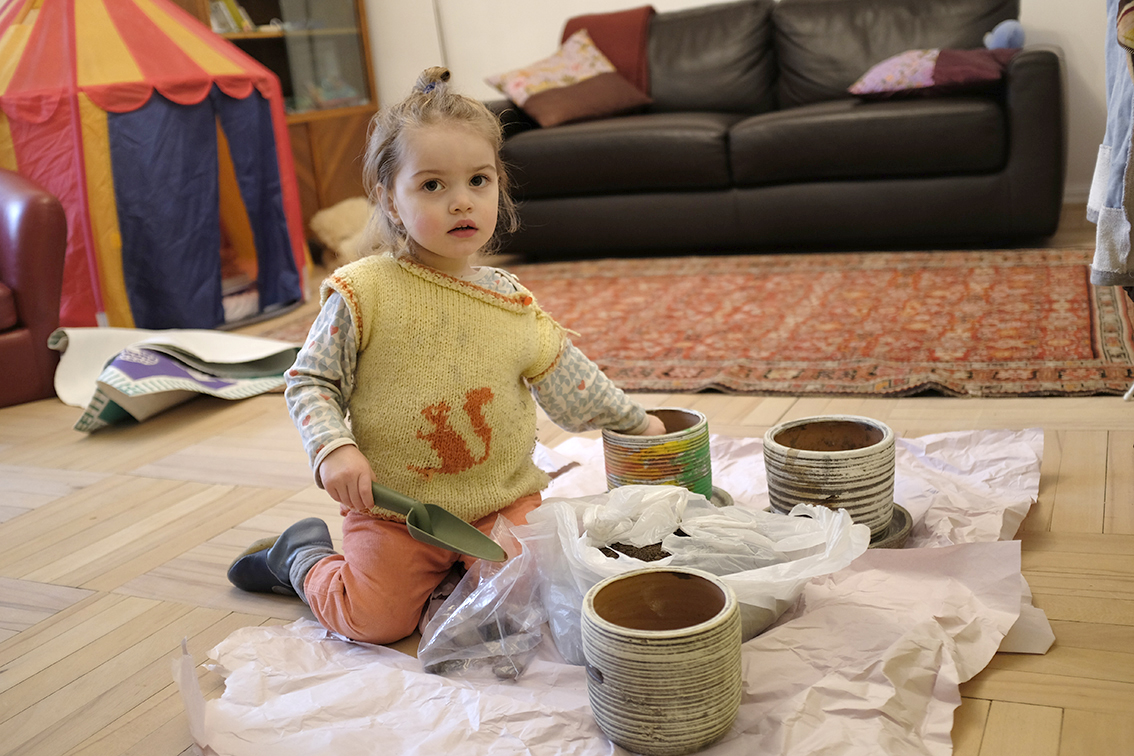 Child Planting Seeds in Flower Pots Using a Shovel