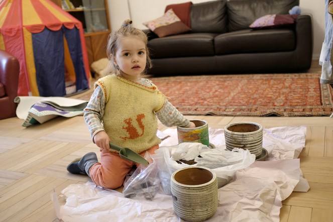 Child Planting Seeds in Flower Pots Using a Shovel