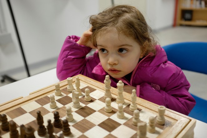 Child playing wooden chess